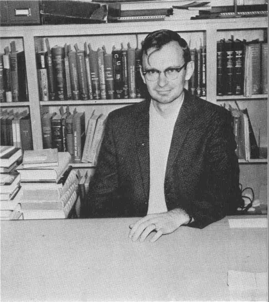 Image of Donald Gray in front of bookshelves.