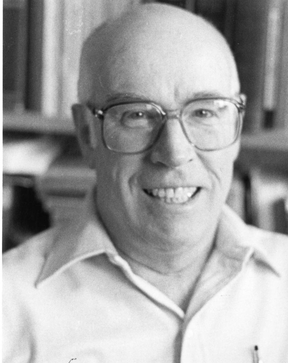 Black and white photograph headshot of William Donald Spring. He's wearing a button down shirt and glasses. 
