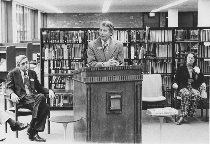 Rodney A. Briggs speaks at a podium in the library during dedication ceremony