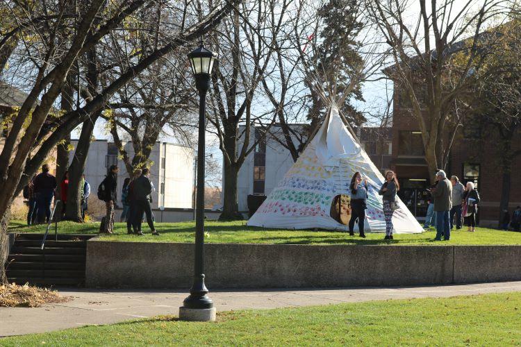 Students stand around a tipi on the Campus Mall