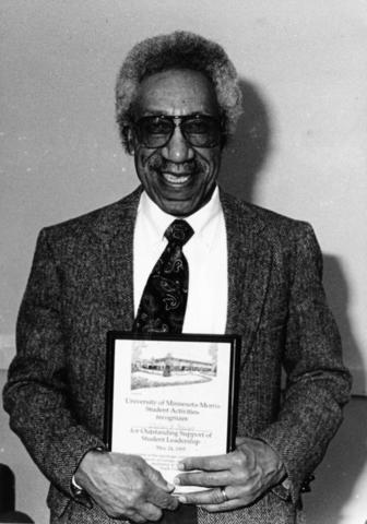 Image of Bill Stewart holding a recognition award. 